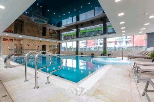 a large swimming pool in a large building at Apartament Rewal in Rewal