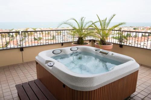 a jacuzzi tub on a balcony with plants at Villa Maria Hotel & SPA in Francavilla al Mare