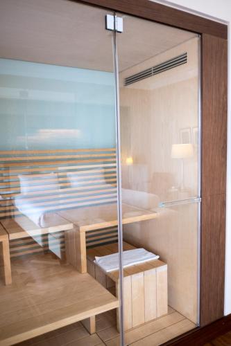 a glass room with a bed and a table at Villa Maria Hotel & SPA in Francavilla al Mare