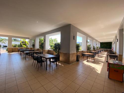 a restaurant with tables and chairs and windows at Hotel Montera Plaza in Los Barrios