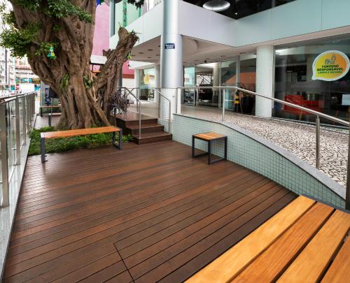 a wooden boardwalk with a tree in a mall at Centromar Hotel in Balneário Camboriú
