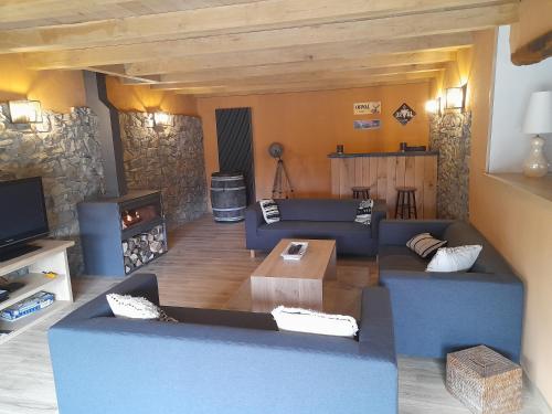 a living room with blue couches and a fireplace at Le refuge de Julia in La Roche-en-Ardenne