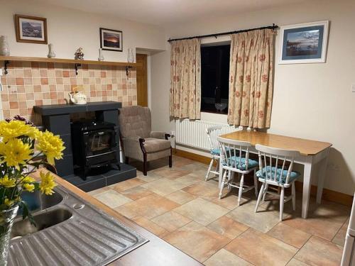 een woonkamer met een tafel en een open haard bij Grogagh Hill Cottage in Sligo