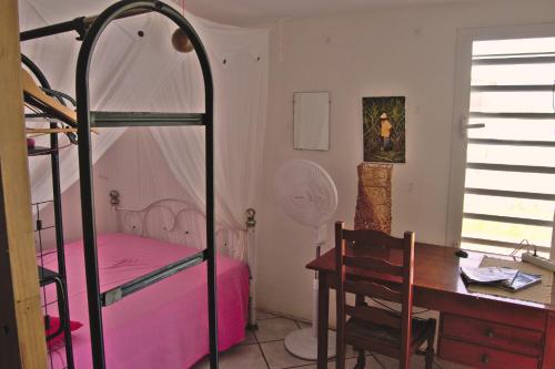 a bedroom with a desk and a bunk bed at Le lit d'Oli in Sainte-Rose