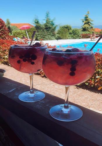 two glasses with cherries in them sitting on a table at Gojim Casa Rural in Armamar