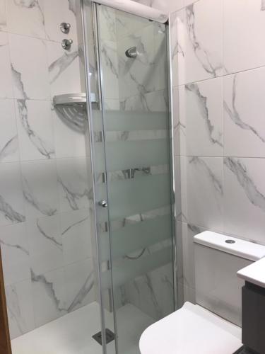 La salle de bains est pourvue d'une douche avec une porte en verre. dans l'établissement Casa Valentin, à Baíñas
