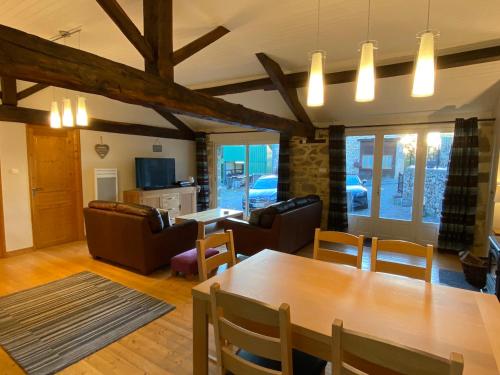 un salon avec une table et des chaises en bois dans l'établissement La Porcherie, à Saint-Mathieu