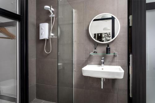 a bathroom with a shower and a sink and a mirror at Curb Properties The Workshop - Super Cool Space! in Cheltenham