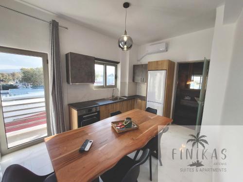 a kitchen with a wooden table and a dining room at Finikas Suites & Apartments Airport By Airstay in Artemida