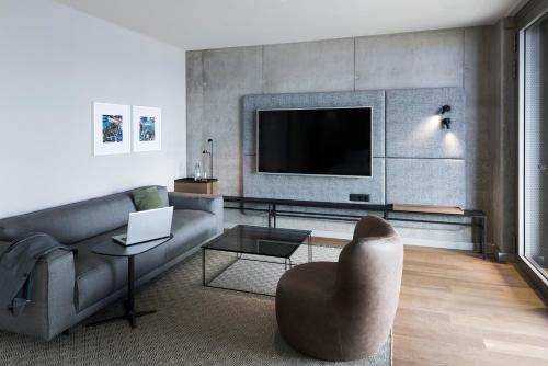 a living room with a couch and a tv at b'mine Hotel Frankfurt Airport in Frankfurt/Main