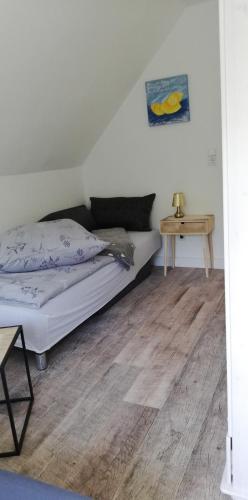 a bedroom with a bed and a wooden floor at Landhaus Löwenzahn in Dornum