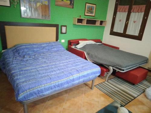 a hospital bed in a room with a green wall at Monolocale sulle piste alle Polle in Riolunato