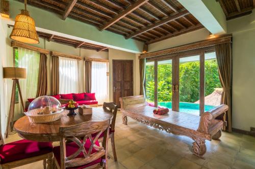 a living room with a wooden table and a couch at The Udaya Resorts and Spa in Ubud