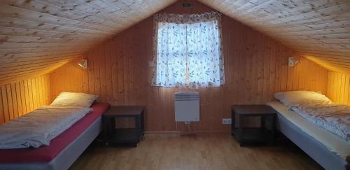 two beds in a room with a window at Vorsabær 2 Holiday Home in Fjall