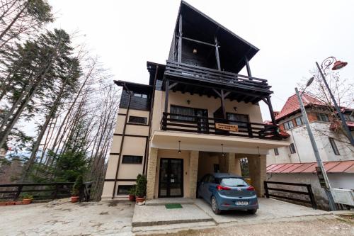 a house with a car parked in front of it at Pension Master in Sinaia