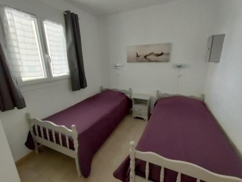 deux lits dans une chambre avec deux fenêtres dans l'établissement ADRECH - 3 pièces, Piscine partagée - SUD6001, à Fréjus