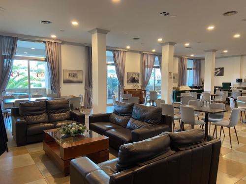 a large living room with couches and tables and chairs at Hotel Montera Plaza in Los Barrios
