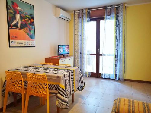 a dining room with a table and chairs and a window at Appartamenti Grado in Grado