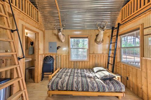 Un dormitorio con una cama en una habitación con paredes de madera. en Lakefront Cabin with 2 Lofts, Boats on 4 Acres, en Winnsboro