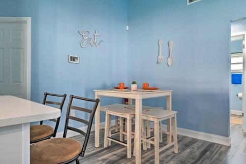 a table and chairs in a room with a blue wall at Port Richey Getaway with Lanai, Pool and Grill! in New Port Richey