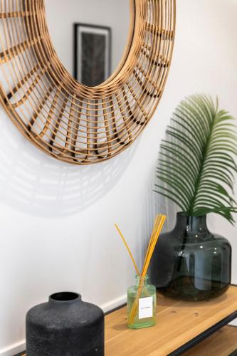 a mirror on a wall above a table with vases at Apartment Confort 404 in Portimão