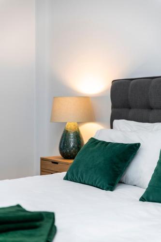 a bedroom with a bed with green pillows and a lamp at Apartment Confort 404 in Portimão