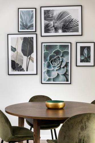 a dining room with a wooden table and framed pictures at Apartment Confort 404 in Portimão