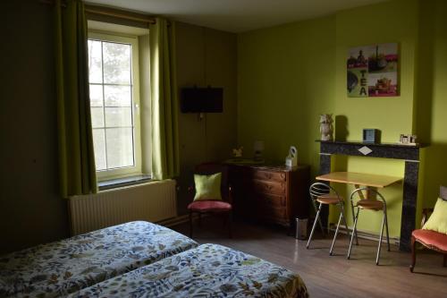 a bedroom with a bed and a table and a desk at B&B La Place Verte in Surice