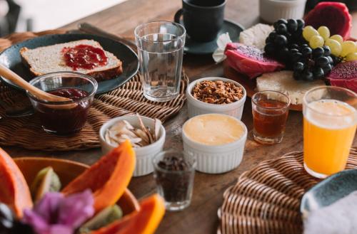 a wooden table topped with plates of food and drinks at Pousada Casa Marae - beira mar in Caraíva