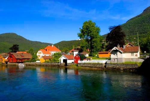 a group of houses next to a body of water at Fagre Stryn Feriehus in Stryn