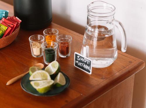 a table with glasses of water and a bowl of lime at Pousada Casa Marae - beira mar in Caraíva