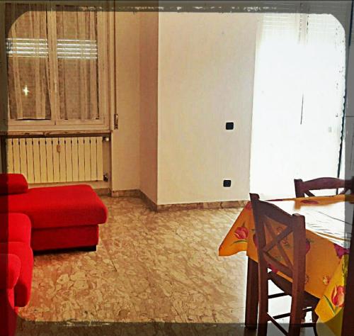 a living room with a red couch and a table at Albenga sul mare famiglie ed amici fino 10 posti in Albenga