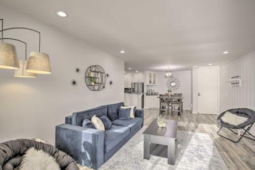 a living room with a blue couch and a kitchen at Charming Oceanside Condo with Beach and Pool Access! in Oceanside