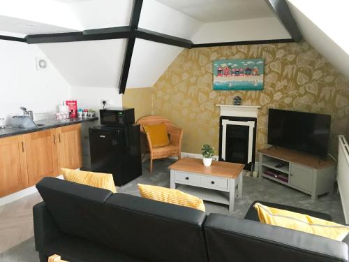 a living room with a couch and a fireplace at The Beach Hut - 1 Bedroom Apartment Near the Beach in Bournemouth