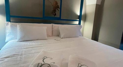 a white bed with a blue headboard and white pillows at Hotel Rural La Casa de Carlota in Montánchez
