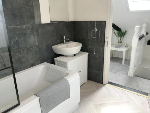 a bathroom with a sink and a bath tub and a sink at April Lodge The Beach Hut - 1Bed Apartment Near the Beach-Parking-Couples-Friends-Professionals-Contractors in Bournemouth