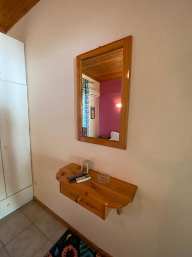 a bathroom with a wooden vanity and a mirror at MARATHES STUDIOS in Agios Nikitas