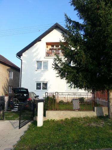 a white house with a fence in front of it at Ubytovanie u Vlasty in Štrba