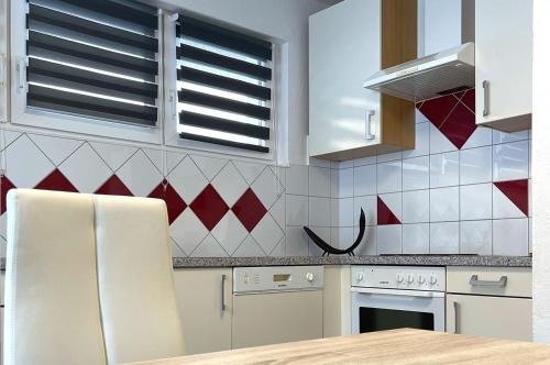 a kitchen with white appliances and red and white tiles at Schöne Ferienwohnung, Familienfreundlich 130m2 in Greifenburg
