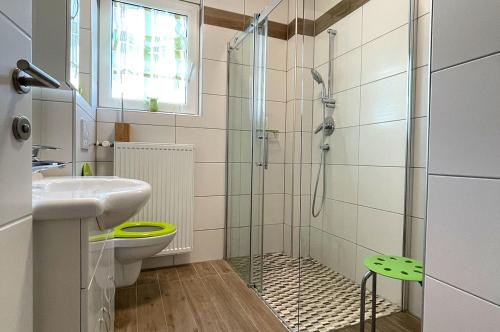 a bathroom with a shower and a toilet and a sink at Schöne Ferienwohnung, Familienfreundlich 130m2 in Greifenburg