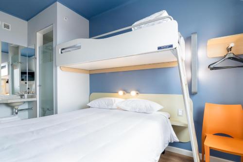 a bedroom with a bunk bed with a blue wall at ibis budget Calama in Calama