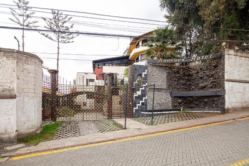 una valla al lado de una calle con un edificio en Hotel Andenes, en Arequipa