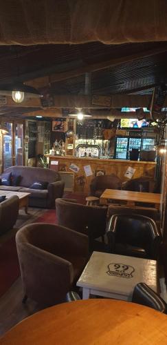 a restaurant with tables and chairs and a bar at Hôtel Restaurant l’Éolienne in Rouxmesnil-Bouteilles