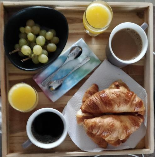 Una bandeja de comida con un plato de croissants y dos tazas de café. en V&Spa 2 chambres d'hôtes avec Spa privatif dont une avec un Sauna, en Saint-Martin-Boulogne