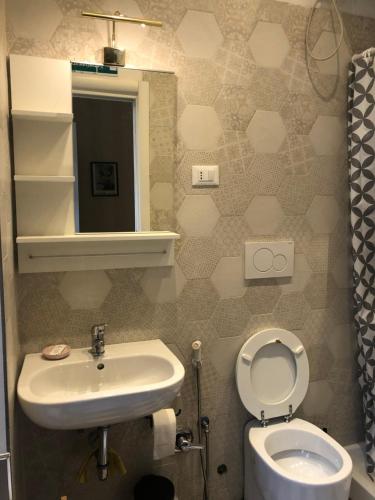 łazienka z umywalką, toaletą i lustrem w obiekcie Ad Maiora Rome Apartment w Rzymie