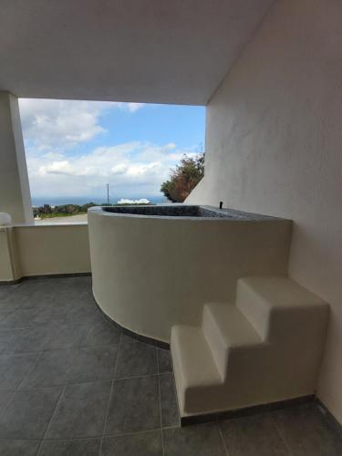 a room with a bench and a large window at Kiklamino Sunset Studios in Oia