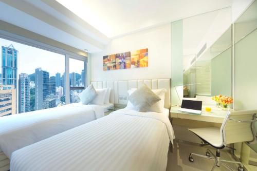 a hotel room with two beds and a desk and a window at iclub Sheung Wan Hotel in Hong Kong