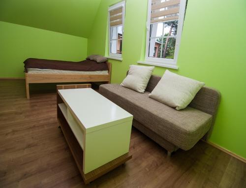 a green room with a couch and a bed at VitaVila in Palanga
