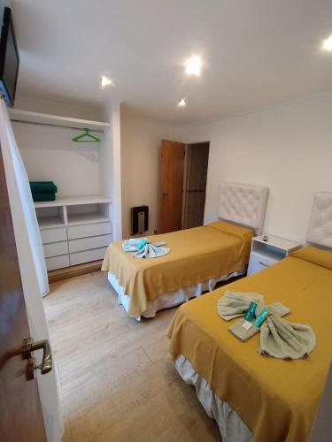 a hotel room with two beds with towels on them at Bianca's Apartament Santa Teresita in Santa Teresita