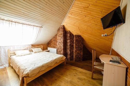 een slaapkamer met een bed en een bureau in een kamer bij Best House in Loetsk